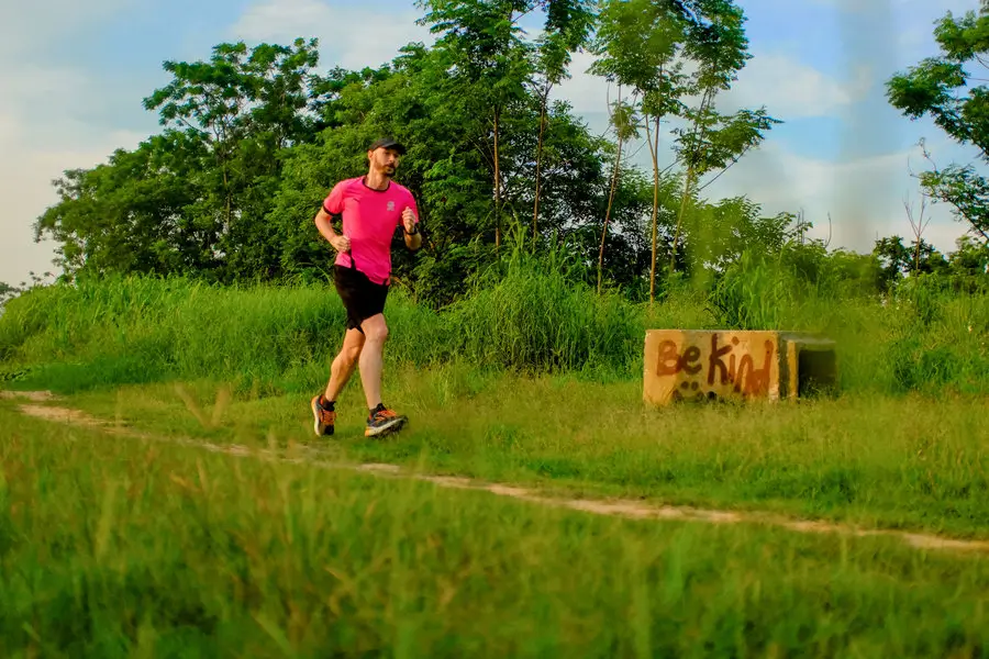 photo of me running by some graffiti that says be kind
